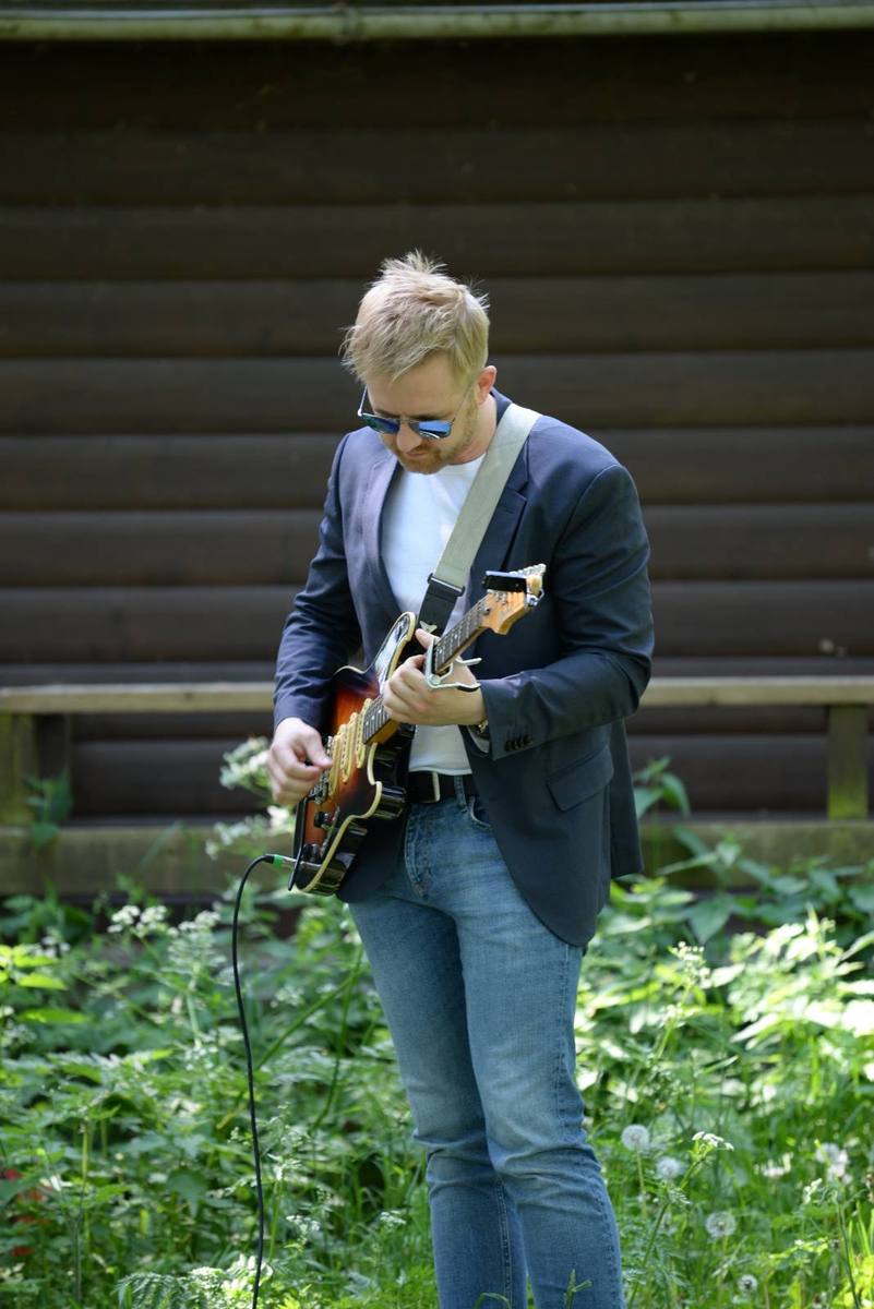 Búgvi playing electric guitar outdoors
